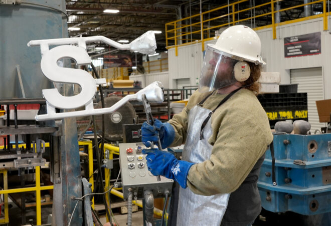Man looking at cast metal letter