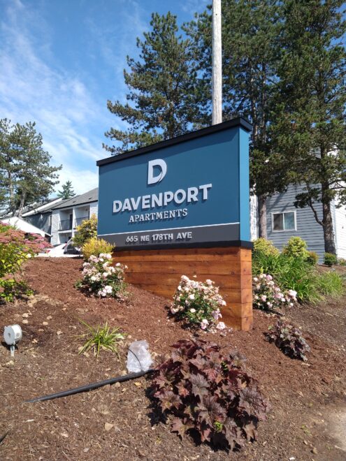 Flat Cut Metal – Exterior (Davenport): Flat cut metal letters for Davenport Apartments mounted on an exterior structure in a garden bed. Apartment signage featuring street addres
